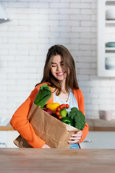 Mulher Alegre Segurando Saco Papel Com Legumes Frescos Cozinha — Fotografia de Stock