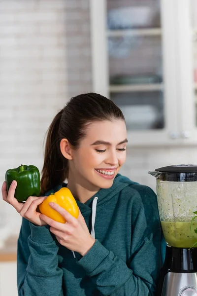 Mujer Complacida Sosteniendo Pimiento Cerca Licuadora Con Batido Fresco Cocina — Foto de Stock