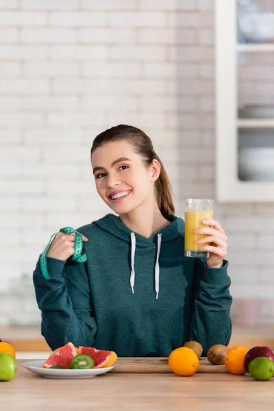 Cheerful Woman Holding Measuring Tape Glass Fruit Juice Kitchen — Stockfoto