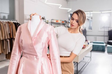 Galeride manken kürkünde pembe ceket giyen güzel bir satıcı. 