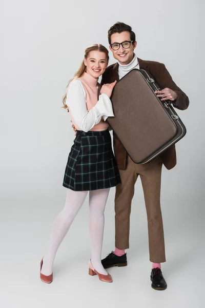 Casal Feliz Roupas Retro Sorrindo Para Câmera Enquanto Segurando Mala — Fotografia de Stock