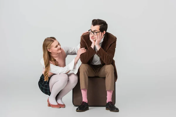 Glimlachende Vrouw Aanraken Beledigd Vriendje Zitten Vintage Koffer Grijze Achtergrond — Stockfoto