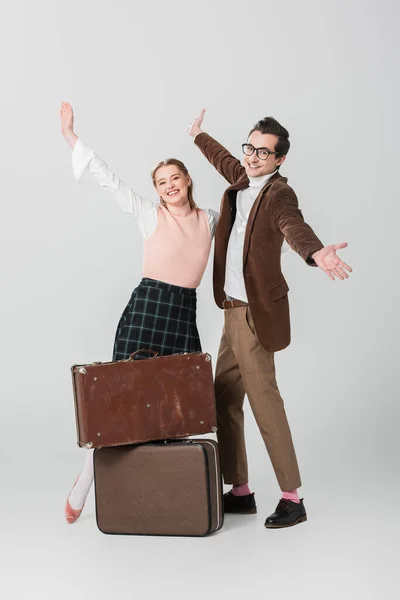 Cheerful Couple Standing Open Arms Vintage Suitcases Grey Background — Stock Photo, Image