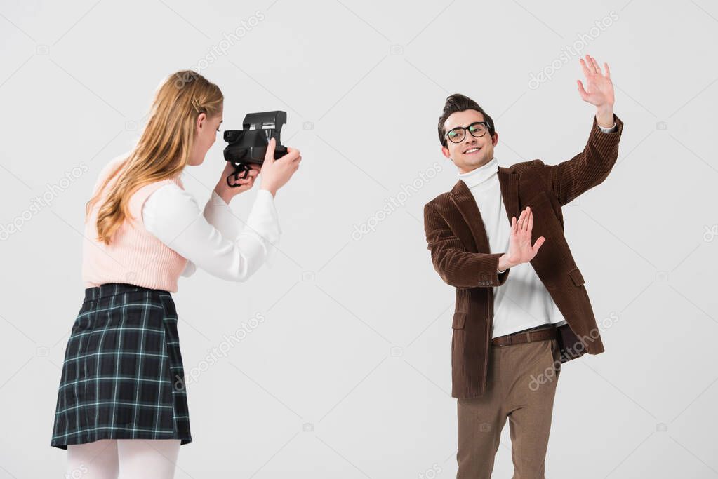 cheerful man posing near woman with vintage camera isolated on grey