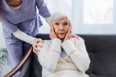 aged woman, sick on amnesia, holding hands near face while social worker touching her shoulders clipart