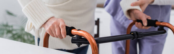 частичный взгляд пожилой женщины, идущей с медицинскими ходунками рядом с медсестрой, баннер