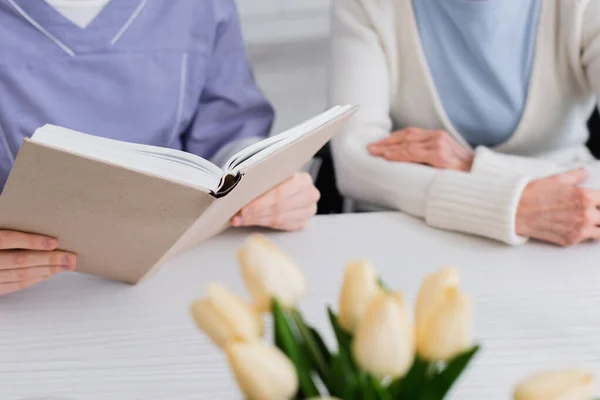 Teilansicht Einer Krankenschwester Die Einer Seniorin Der Nähe Von Tulpen — Stockfoto