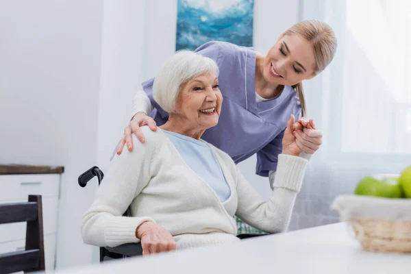 Enfermera Sonriente Cogida Mano Con Mujer Discapacitada Alegre Casa —  Fotos de Stock