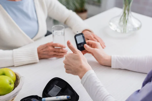 Cropped View Social Worker Showing Thumb Glucometer Senior Diabetic Woman — Stock Photo, Image