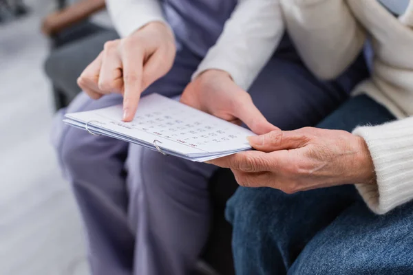 Visión Parcial Trabajadora Social Señalando Calendario Cerca Mujer Anciana Enferma — Foto de Stock