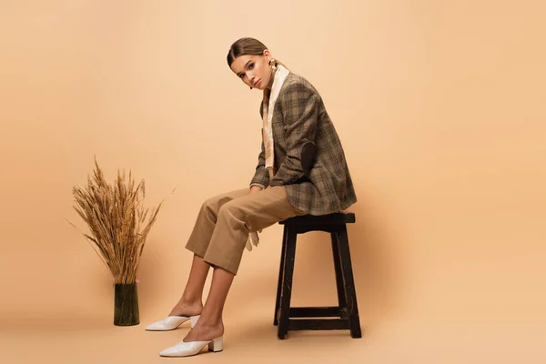 Young Woman Trendy Blazer Pants Sitting Stool Vase Spikelets Beige — Stock Photo, Image