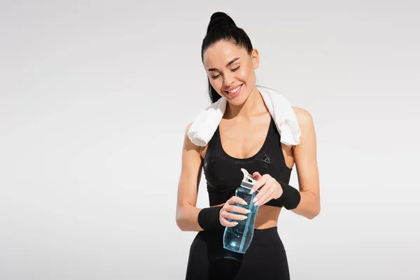 Smiling Sportswoman Towel Shoulders Holding Sports Bottle Isolated Grey — Stock Photo, Image