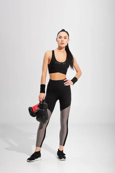 Full Length Brunette Sportswoman Holding Boxing Gloves While Posing Hand — Stock Photo, Image