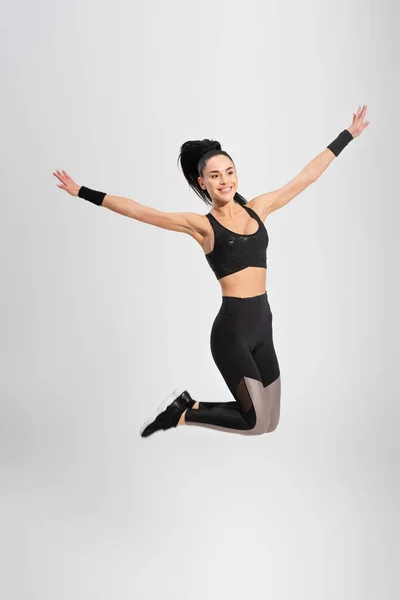 Full Length Happy Young Woman Levitating Outstretched Hands Grey — Stock Photo, Image