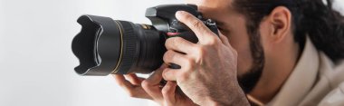 İspanyol fotoğrafçı modern dijital kamerada fotoğraf çekiyor. Beyaz pankartta izole edilmiş.