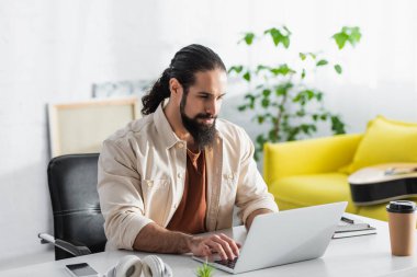Sakallı İspanyol serbest yazar. Bilgisayarında kahve ve akıllı telefon için daktilo yazıyor.
