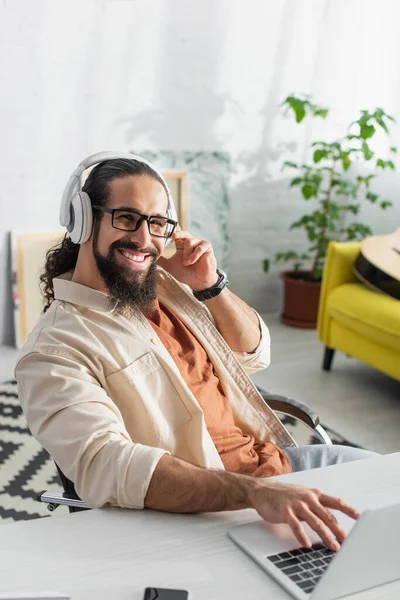 Bearded Hispanic Freelancer Headphones Smiling Camera While Listening Music Blurred — Stock Photo, Image