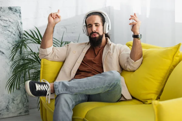 Latin adam kapalı gözlerle müzik dinlerken jest yapıyor ve ıslık çalıyor.