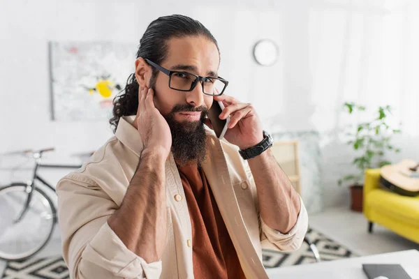 Bärtiger Hispanischer Mann Schaut Die Kamera Während Wohnzimmer Mit Dem Stockfoto