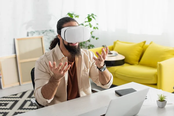 Freelancer Hispano Auriculares Gestos Cerca Computadora Portátil Casa Imagen De Stock