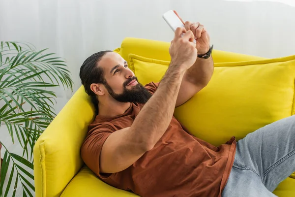 Barbudo Latino Homem Tomando Selfie Celular Enquanto Deitado Sofá Casa Fotos De Bancos De Imagens