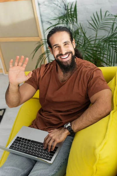 Homem Latino Feliz Acenando Mão Câmera Enquanto Sentado Sofá Com Imagens De Bancos De Imagens Sem Royalties