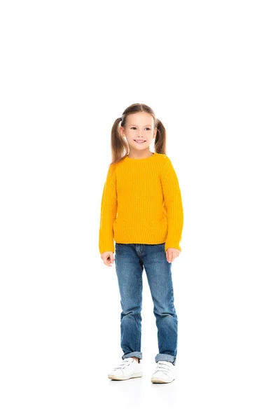 Lächelndes Mädchen schaut weg, während es auf weißem Hintergrund steht — Stockfoto