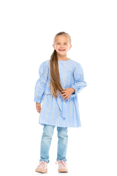 Cheerful girl in dress and jeans looking at camera on white background — Stock Photo