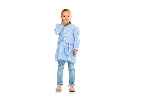 Excited child covering mouth with hand while looking at camera on white background — Stock Photo
