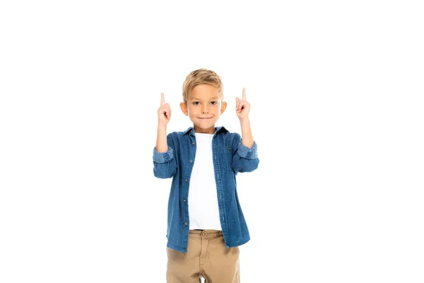 Позитивний хлопчик дивиться на камеру, вказуючи пальцями ізольовано на білому — стокове фото
