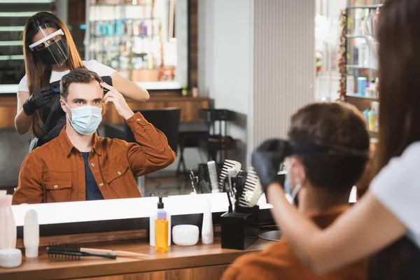 Specchio riflesso del parrucchiere in viso scudo taglio capelli dell'uomo che punta con le dita, primo piano sfocato — Foto stock