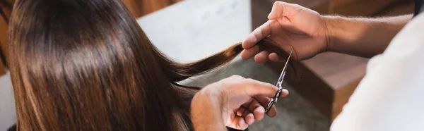 Partial view of barber cutting hair of woman on blurred foreground, banner — Stock Photo