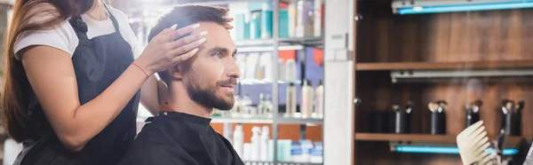 Coiffeur toucher les cheveux de jeune homme barbu, bannière — Photo de stock