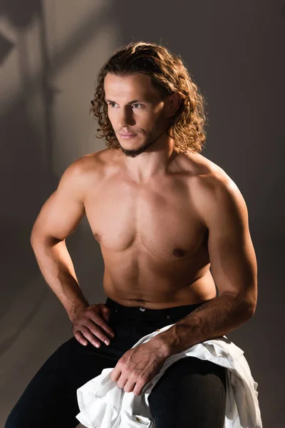 Sexy shirtless man with long hair posing on dark background — Stock Photo