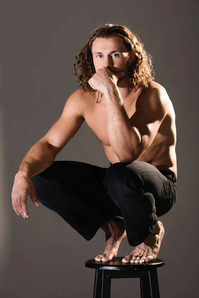 Pensive sexy shirtless man with long hair posing on dark background — Stock Photo