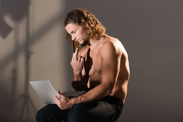 Sexy sem camisa homem segurando laptop e cartão de crédito — Fotografia de Stock