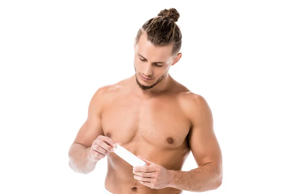 Sexy shirtless man in towel with hand cream isolated on white — Stock Photo