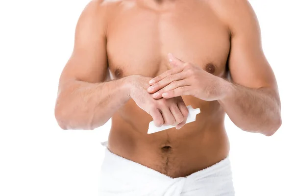 Recortado vista de sexy hombre sin camisa en la toalla aplicación de crema de manos aislado en blanco - foto de stock