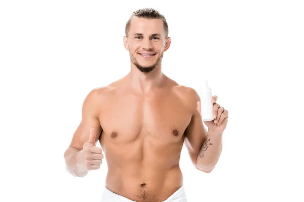 Smiling sexy shirtless man in towel holding foam and showing thumb up isolated on white — Stock Photo