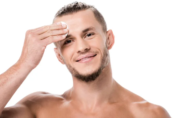 Sonriente sexy hombre sin camisa usando algodón almohadilla aislado en blanco - foto de stock