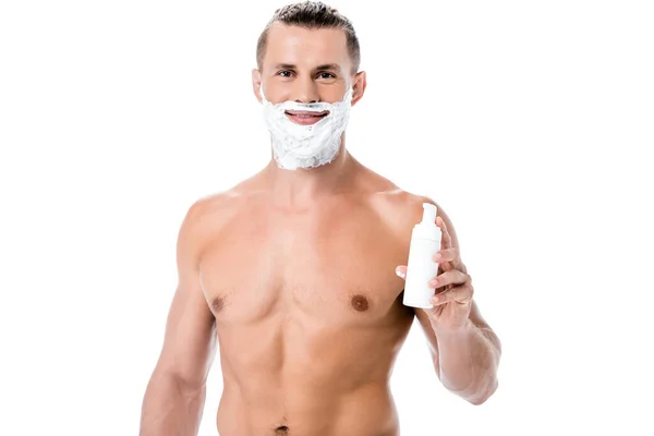 Smiling sexy shirtless man holding shaving foam isolated on white — Stock Photo