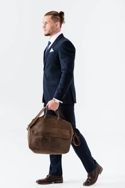 Молодой бизнесмен в костюме с чемоданом, изолированным на белом — стоковое фото