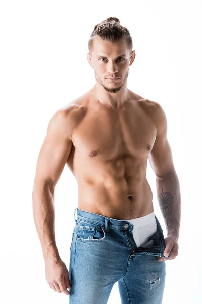 Сексуальный мужчина без рубашки в джинсах позирует изолированно на белом — стоковое фото