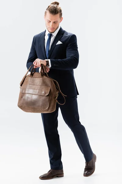 Giovane uomo d'affari in completo con valigia isolata su bianco — Foto stock