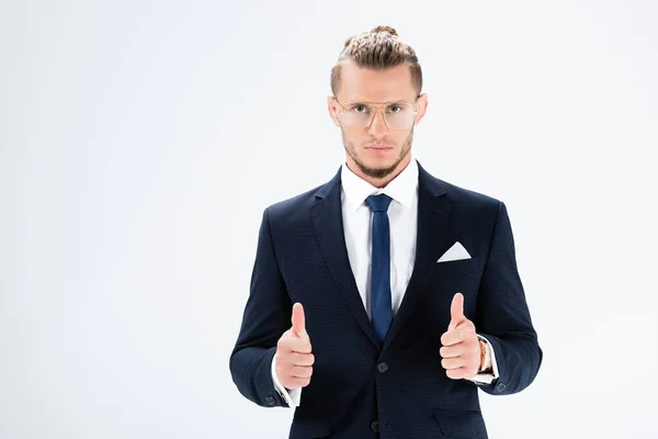Young businessman in suit and glasses showing thumbs up isolated on white — Stock Photo