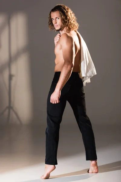 Back view of sexy shirtless man with long hair posing on dark background — Stock Photo