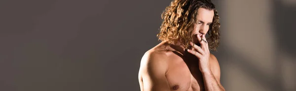 Sexy uomo senza maglietta con i capelli lunghi fumare su sfondo scuro, banner — Foto stock