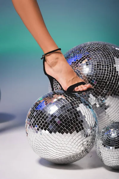 Gamba femminile in scarpa nera su disco ball — Foto stock