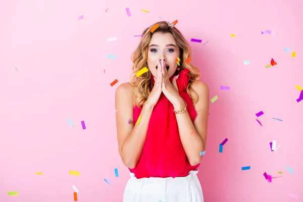 Elegant shocked woman in crown under confetti on pink background — Stock Photo