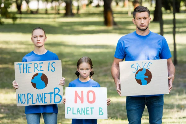 Casal com filha segurando cartazes com globo, salvar, e não há inscrição planeta b, conceito de ecologia — Fotografia de Stock